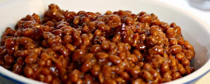 Smoked BBQ baked beans in a cast-iron serving pan