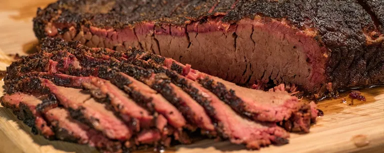 Freshly sliced 12Eleven Catering smoked brisket showing a deep pink smoke ring